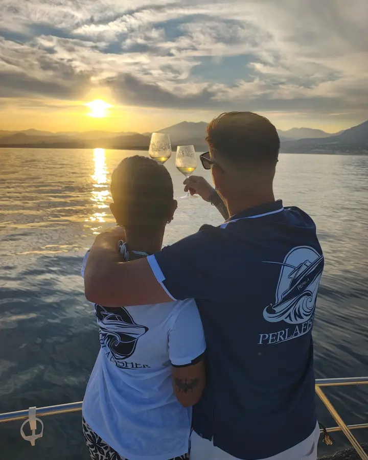 Pareja brindando al atardecer a bordo del Perla Fisher