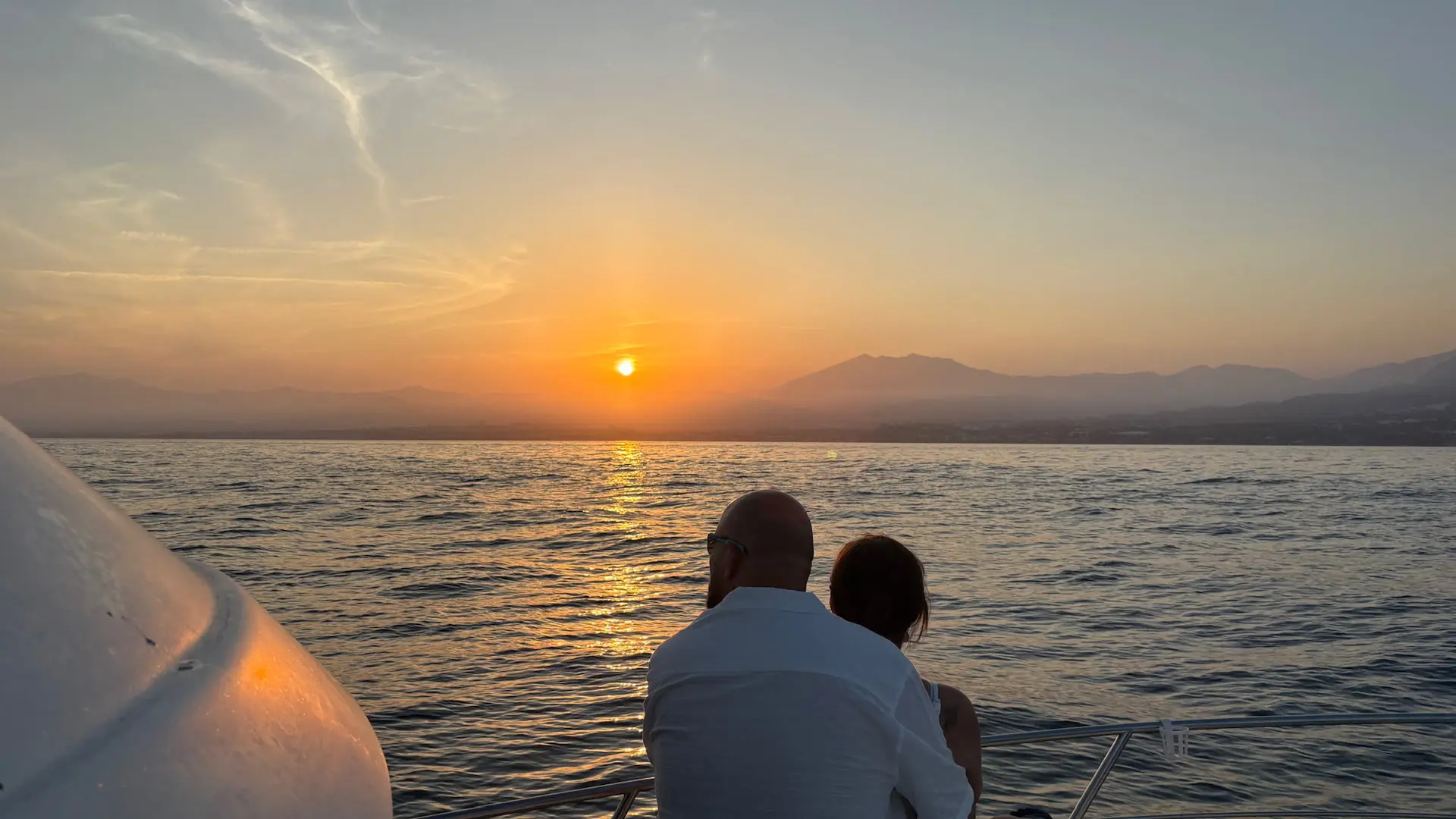Pareja viendo el atardecer desde la proa del Perla Fisher