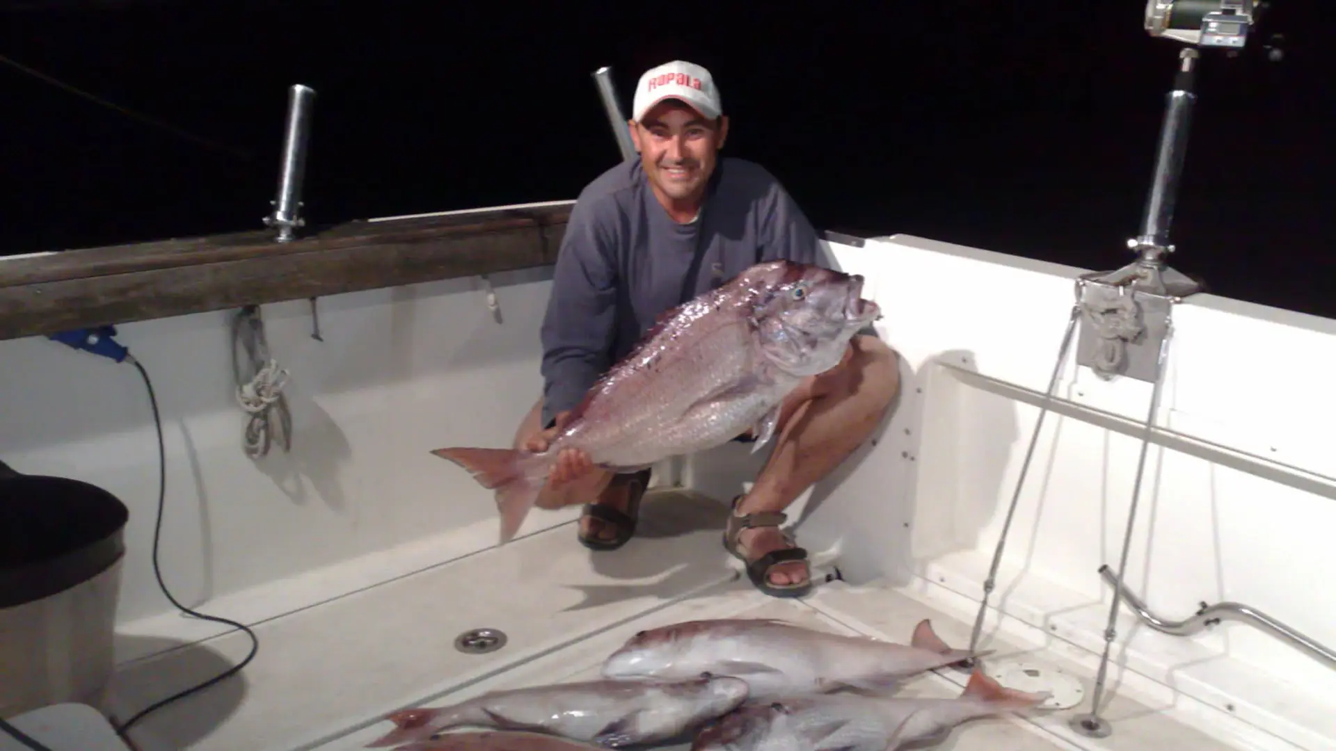 Pescador con un pargo en la cubierta del Perla Fisher